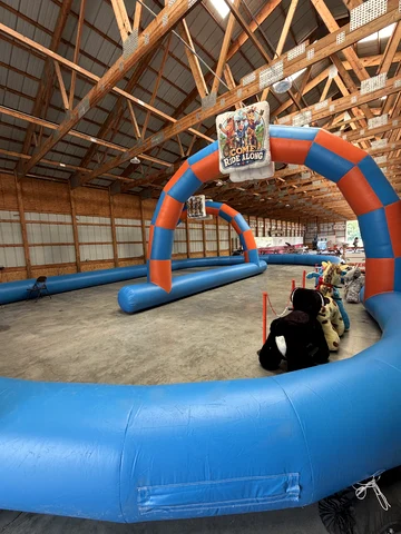 The inflatable track and arch set up inside a wooden barn on a concrete floor